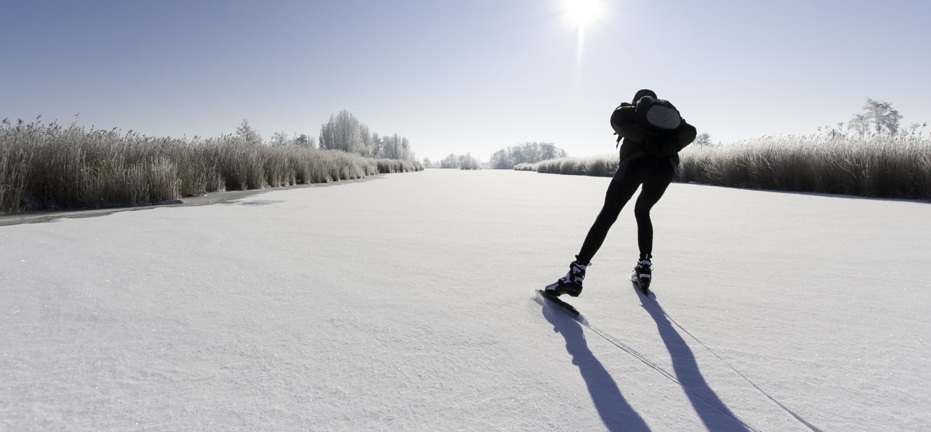 Schaatser, schaatst door winters landschap